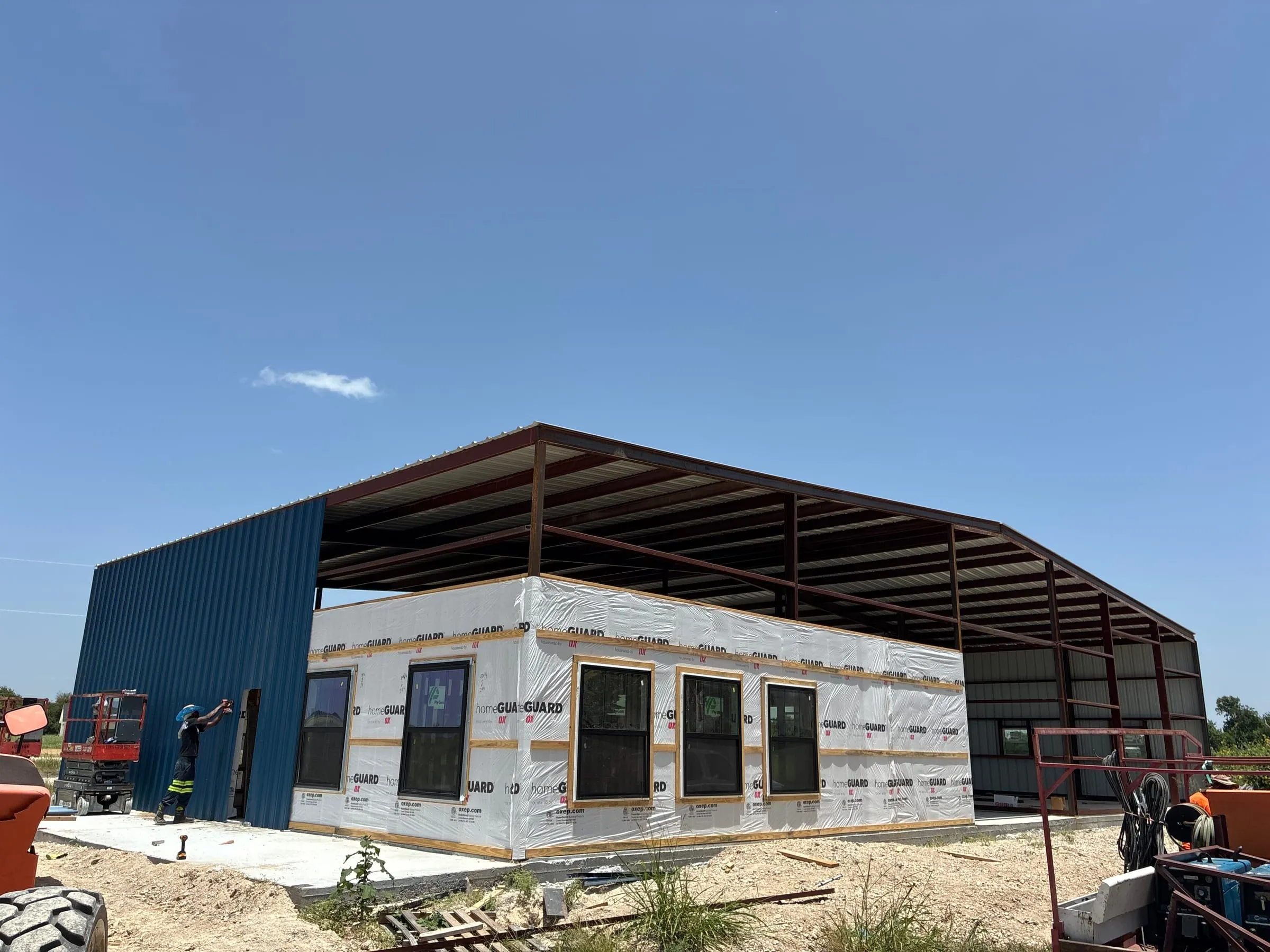 Wide exterior view of the blue home and shop during construction.