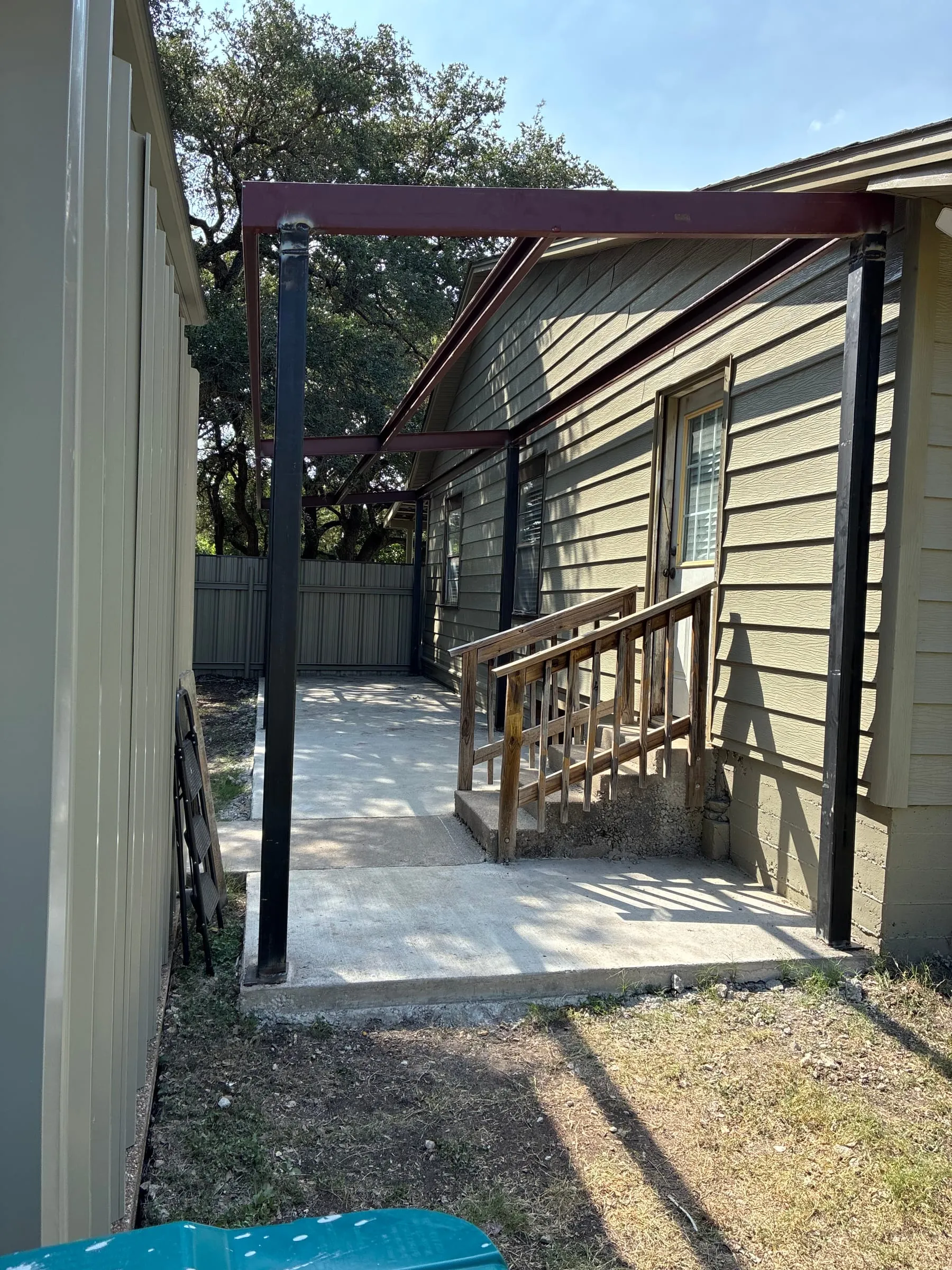 Covered walkway beside the home with the existing wood railing.