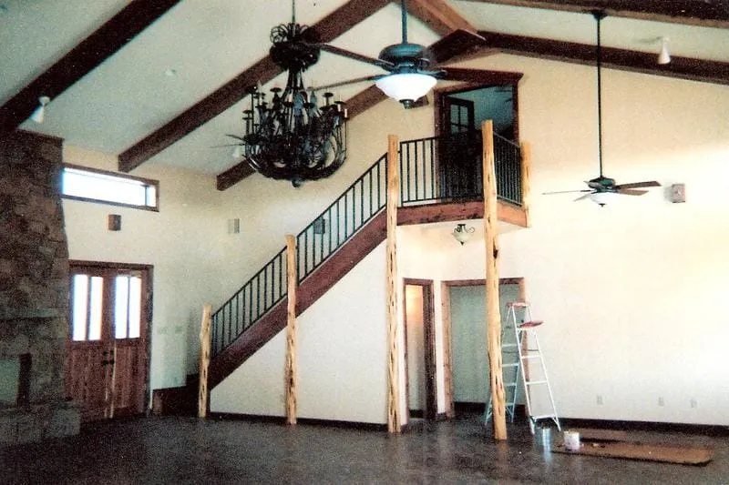 Two-story living room with staircase, chandelier, and cedar trim.