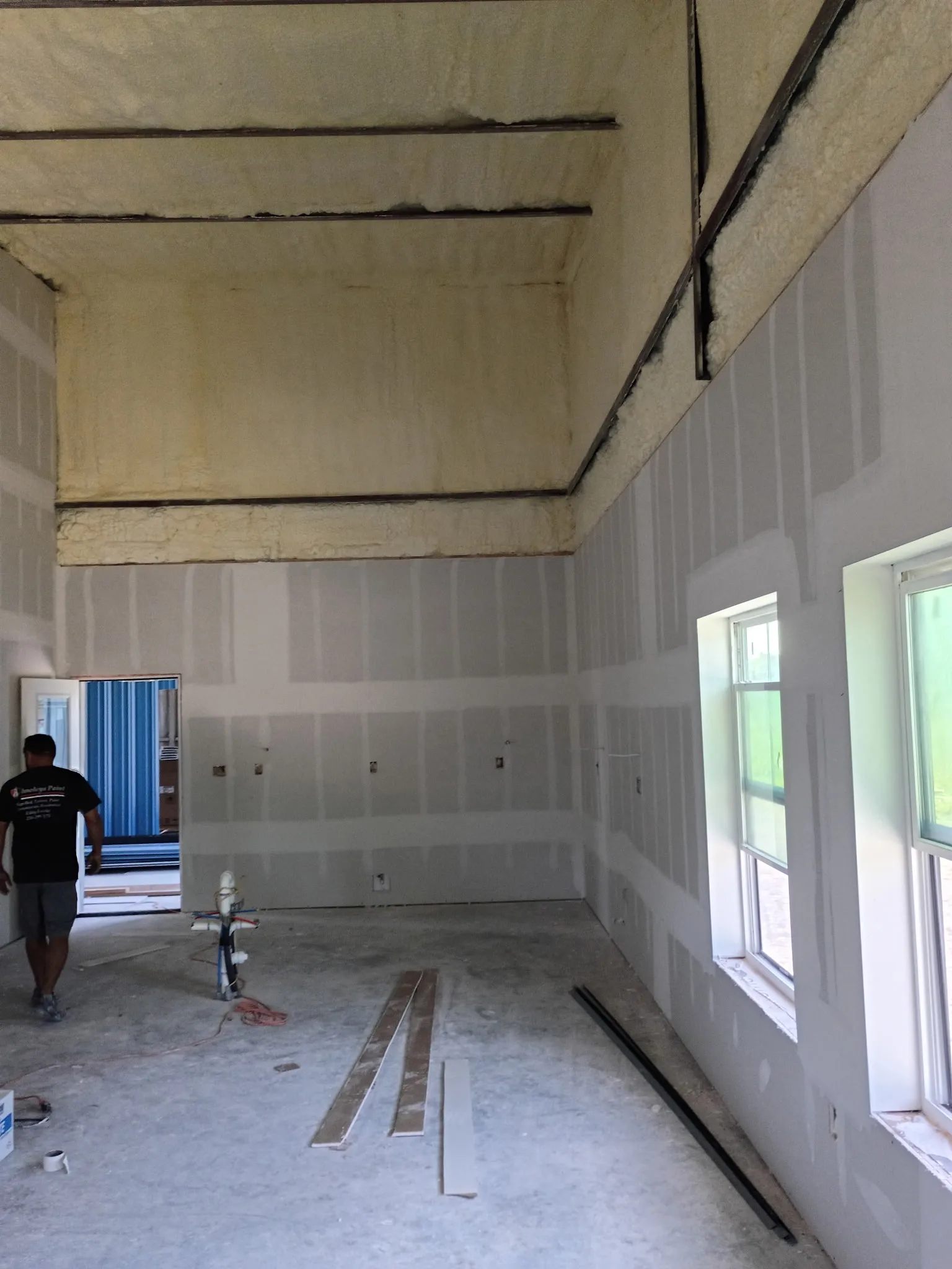 Long open interior room with drywall beneath the insulated steel roof structure.