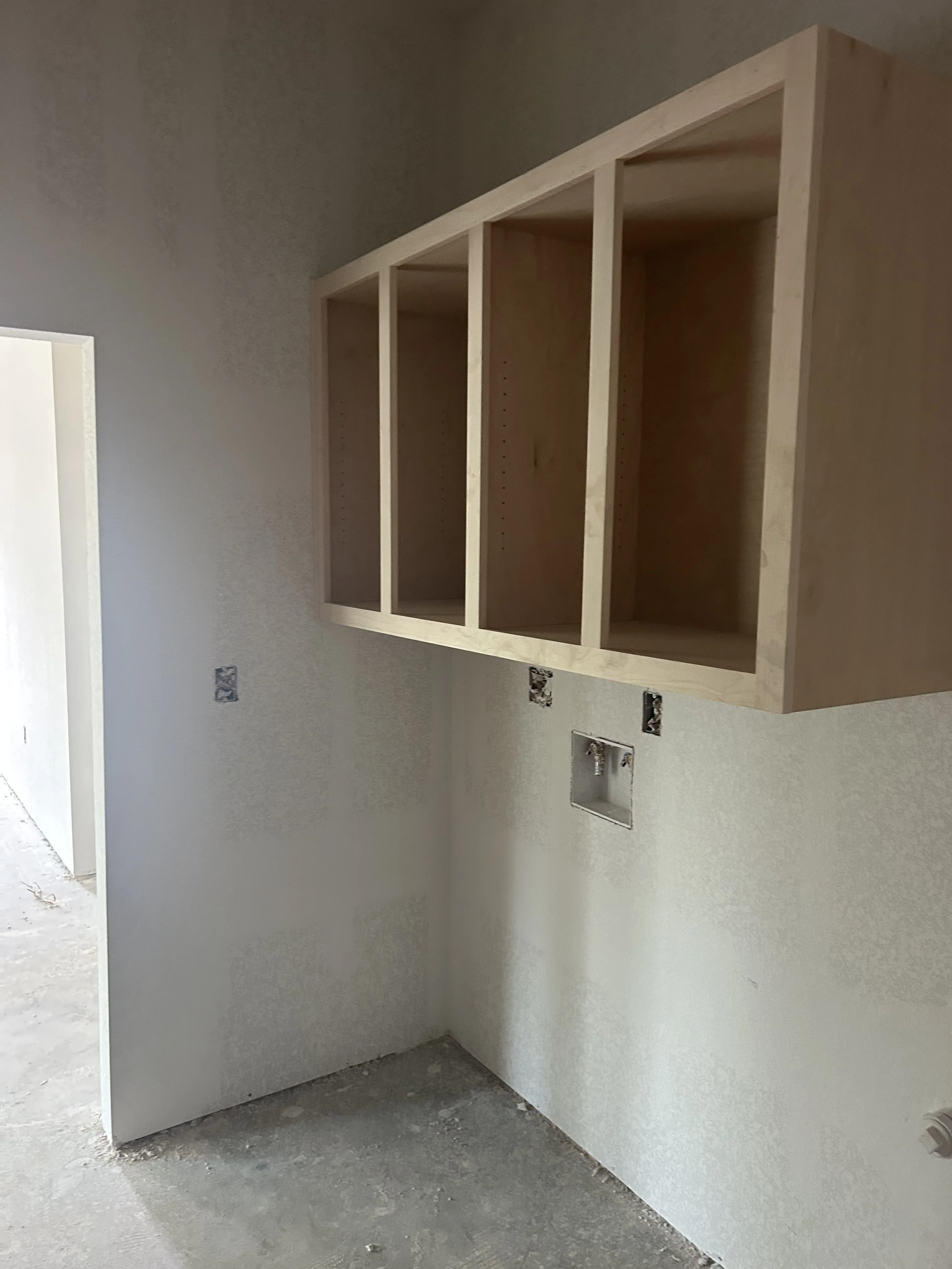Unfinished custom wall cabinets installed during the interior build-out.