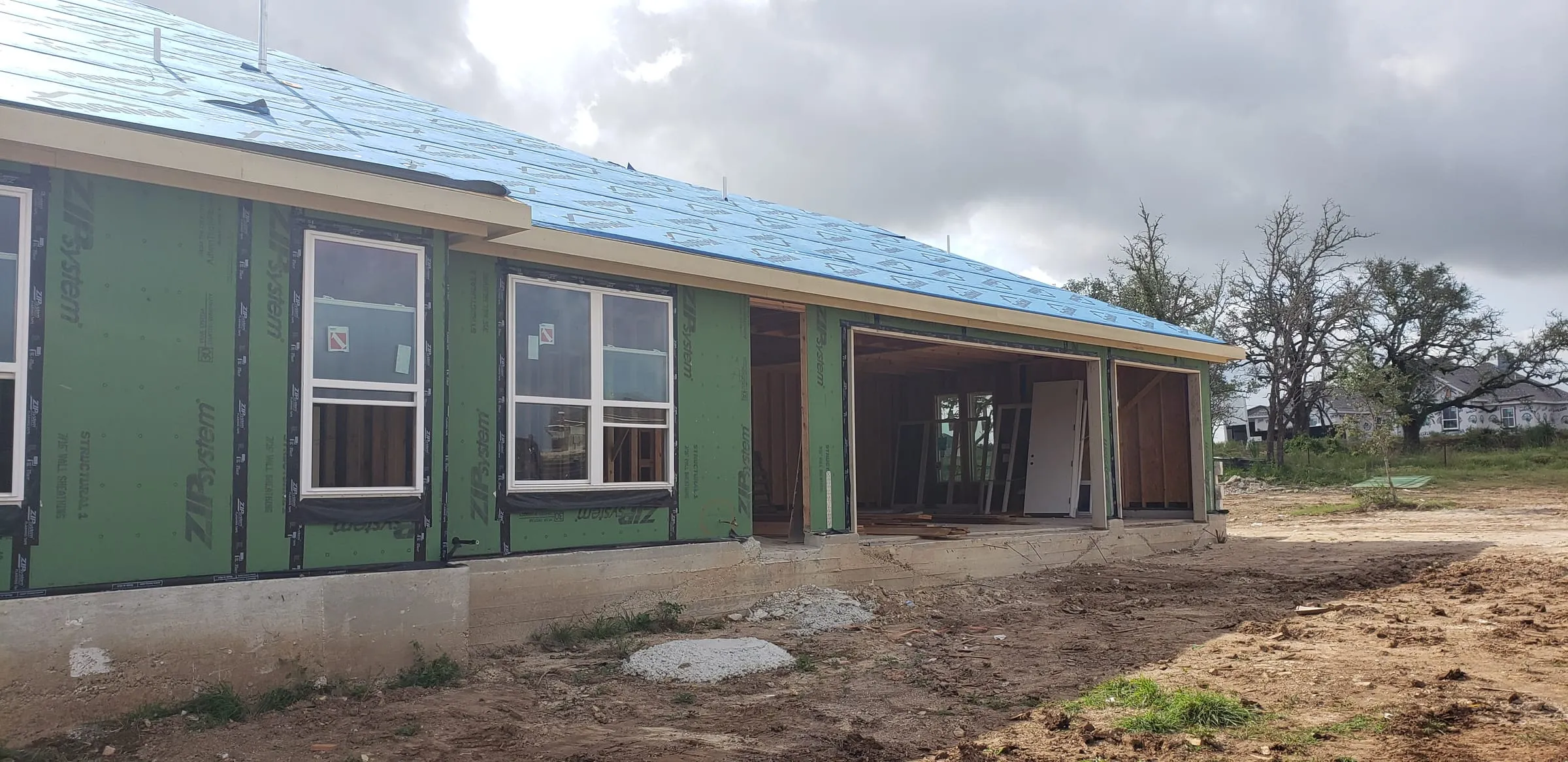 Home dried in with windows set and garage framed during construction.