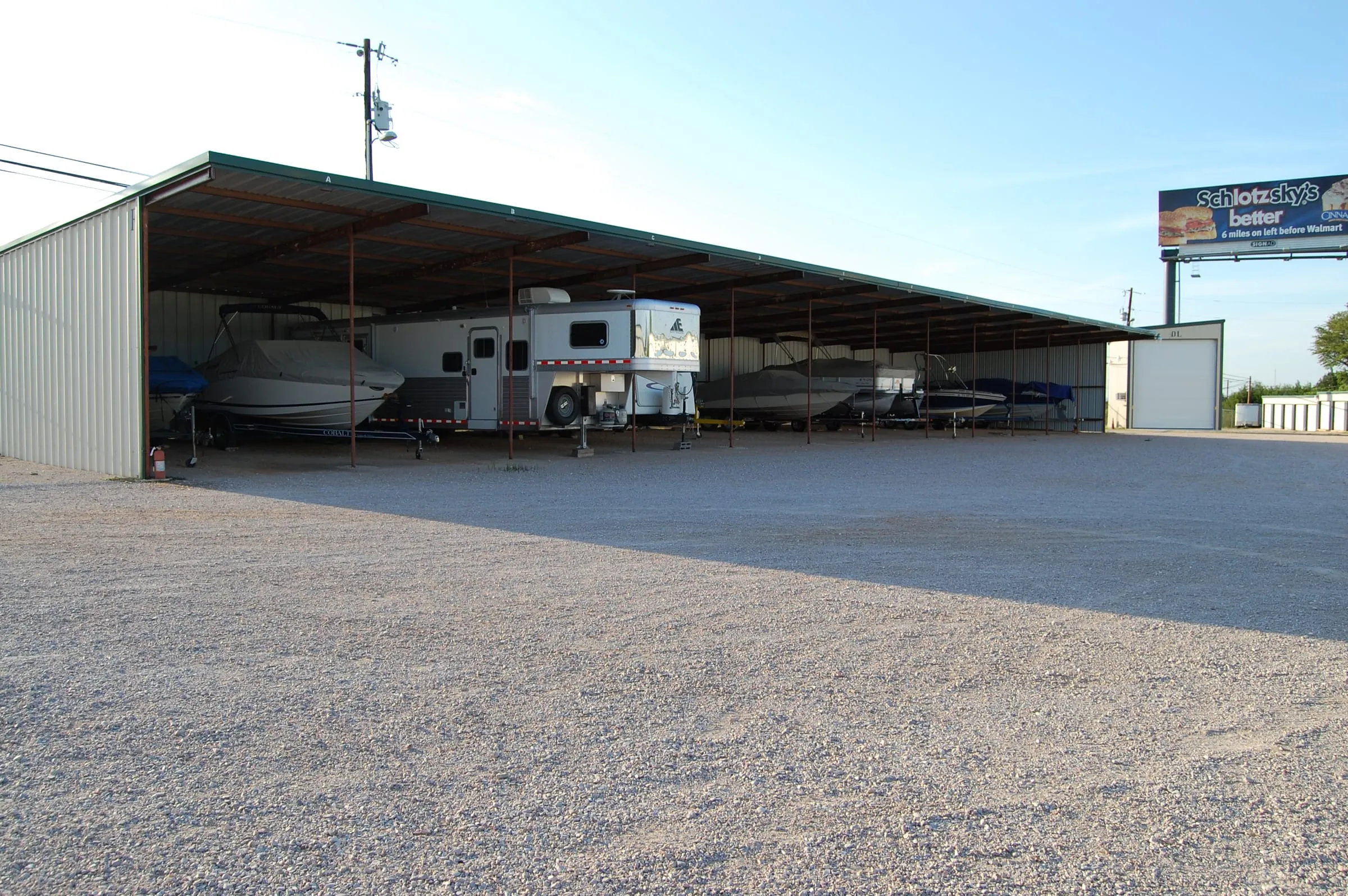 Open-air boat and trailer storage canopy with steel columns.